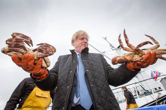 Boris Johnson holds crabs at Stromness Harbour, Orkney, during a visit to Scotland in July last year (Picture: Robert Perry/PA Wire)