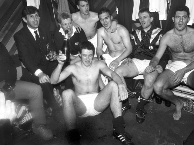 Some of the Scotland rugby squad singing in the changing rooms at Murrayfield after their win over England. Team manager Ian McGeechan joins in (left) as Tony Stanger bags the bottle of champagne.