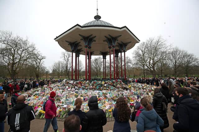 People view floral tributes left at the band stand in Clapham Common, London, after clashes between police and crowds who gathered on Clapham Common on Saturday night to remember Sarah Everard. Picture: Steve Parsons/PA Wire