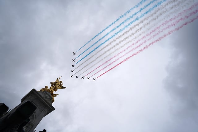 A general view of flypast by aircraft from the Red Arrows over the Mall following the coronation of King Charles III and Queen Camilla in London