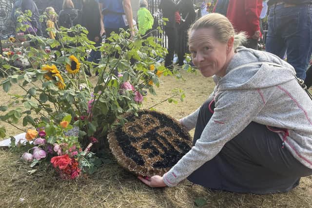 Florist Becky Lindl travelled from Bathgate in West Lothian to lay her own handmade tribute to the Queen -- the royal insignia created using hand-sprayed chrysanthemums -- in the gardens of Holyrood Palace. Picture: Ilona Amos