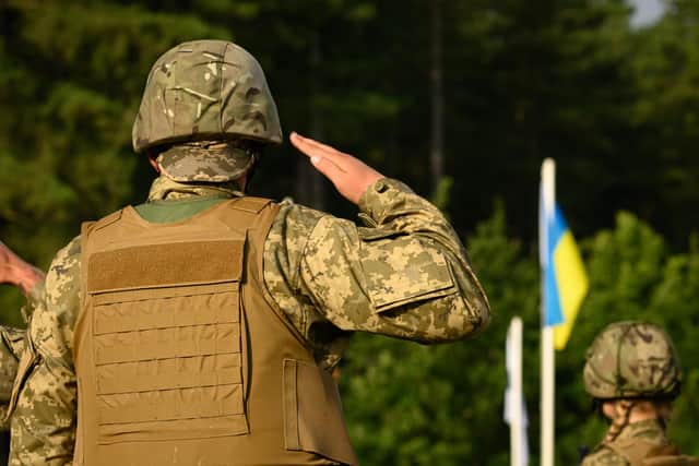 A Ukrainian recruit salutes his country’s flag during a commemorative service marking Ukrainian Independence Day - 24 August - at a UK training camp (Picture: Leon Neal/Getty Images)
