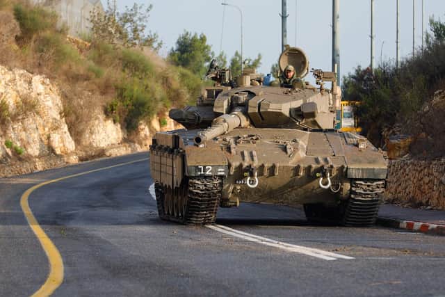 An Israeli army Merkava tank blocks one of the entrances to the northern Israeli kibbutz of Misgav Am near the border with Lebanon. Israeli strikes on Lebanon killed three Hezbollah members amid surging tensions after Palestinian militants tried to infiltrate Israel from Lebanon, in an escalation on Israel's northern border two days after Hamas militants launched an unprecedented attack on the country's southern flank from the blockaded Gaza Strip. (Photo by Jalaa MAREY / AFP) (Photo by JALAA MAREY/AFP via Getty Images)