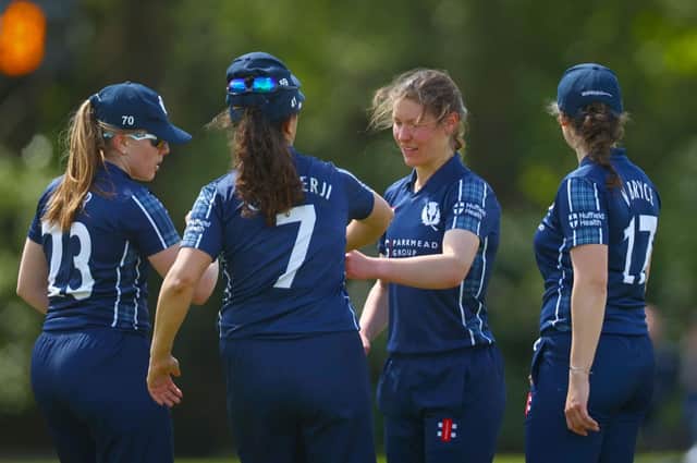 Katie McGill celebrates taking the third wicket for Scotland.