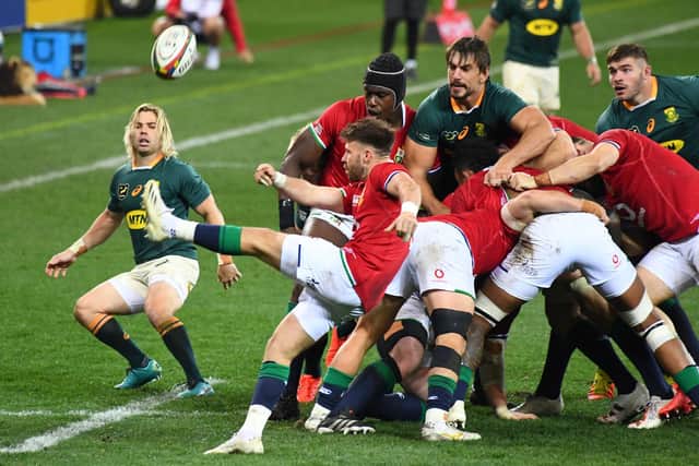South Africa's scrum-half Faf de Klerk watches as Lions opposite number Ali Price clears the ball.