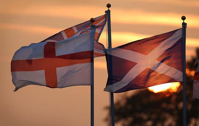 GRETNA GREEN, SCOTLAND - SEPTEMBER 16:  The sun sets behind the Union flag (C), the flag of England (L) and the Scottish Saltire (R) on September 16, 2014 in Gretna Green, Scotland. Yes and No supporters are campaigning in the last two days of the referendum to decide if Scotland will become an indpendent country.  (Photo by Peter Macdiarmid/Getty Images)