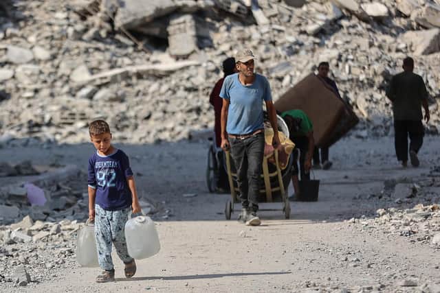 A boy carries water containers as Palestinians displaced by the conflict go on with their lives at the Qatari-built Hamad City residential complex in northwestern Khan Yunis, in the southern Gaza Strip (Picture: Omar Al-Qattaa/AFP via Getty Images)