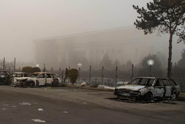 A picture shows burnt-out cars at a parking area near administrative buildings in central Almaty on January 6, 2022. Photo by ALEXANDER BOGDANOV/AFP via Getty Images.
