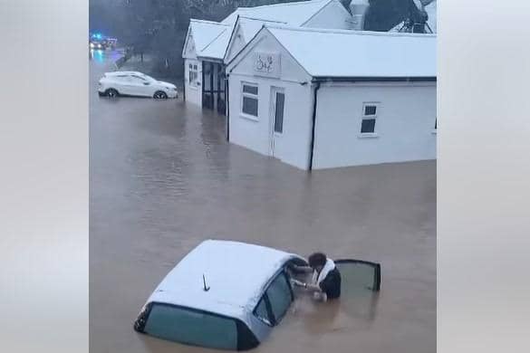 Woman is pulled from car during heroic flood rescue