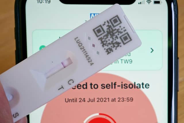 A negative lateral flow test next to advice from the NHS COVID app to self isolate. Picture: Martin Keene/PA Wire