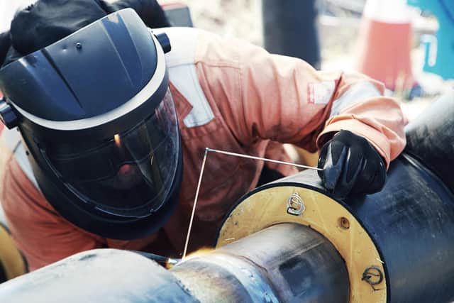 A welder joins pipes for the district heat network being built at the new Shawfair housing development on the outskirts of Edinburgh