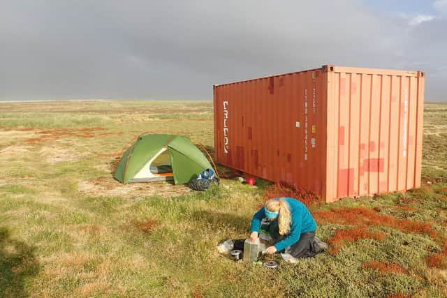 Charly at the tent they set up, in the shelter of an old shipping container, at the northern most point of the Falkland islands on a

camping holiday