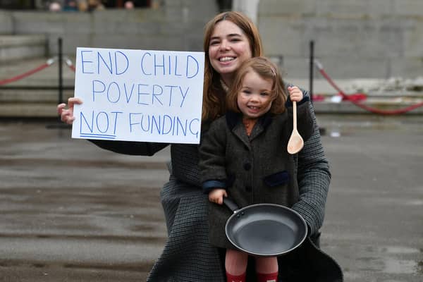 Laura Martin, a member of One Parent Families Scotland, and her daughter Remy protest against cuts to charity funding in Glasgow's George Square (Picture: John Devlin)