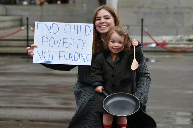 Laura Martin, a member of One Parent Families Scotland, and her daughter Remy protest against cuts to charity funding in Glasgow's George Square (Picture: John Devlin)