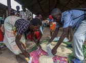 A displaced woman gets her ration of maize at a camp for people displaced by flash floods in Bangula, southern Malawi, in 2019 (Picture: Amos Gumulira/AFP via Getty Images)