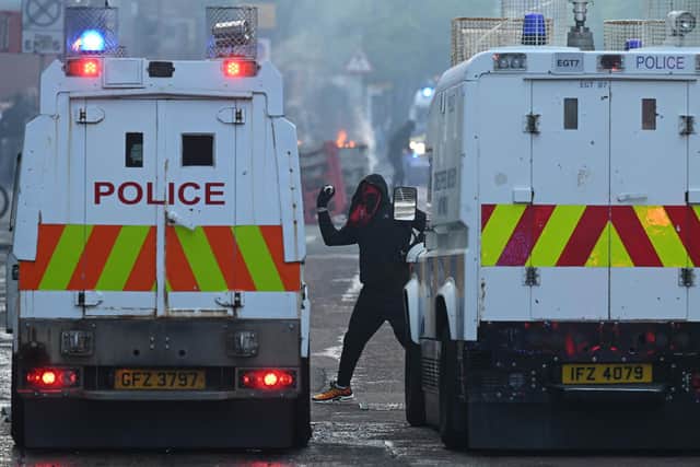 A protestor throws a rock at police vehicles during the disorder on Tuesday. Picture: Charles McQuillan/Getty Images