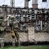 Russian soldiers stand guard at the Luhansk power plant in the town of Shchastya. This picture was taken during a trip organised by the Russian military. (Photo by Alexander NEMENOV / AFP)