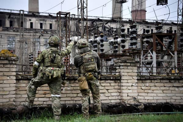 Russian soldiers stand guard at the Luhansk power plant in the town of Shchastya. This picture was taken during a trip organised by the Russian military. (Photo by Alexander NEMENOV / AFP)