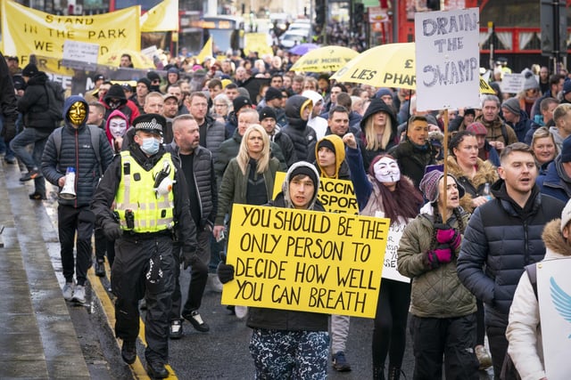 Thousands of people marching wearing masks and carrying signs to support their message.