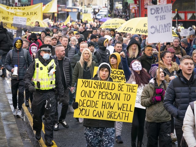 Thousands of people marching wearing masks and carrying signs to support their message.