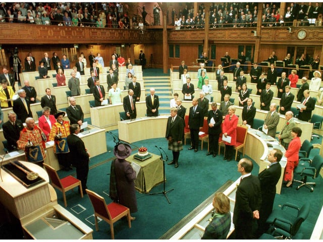 Her Majesty The Queen accompanied by the Royal Party look on as the 15th Duke of Hamilton presents the Crown of Scotland to the Chamber during the Opening of The Scottish Parliament in Edinburgh on 1 July 1999.
