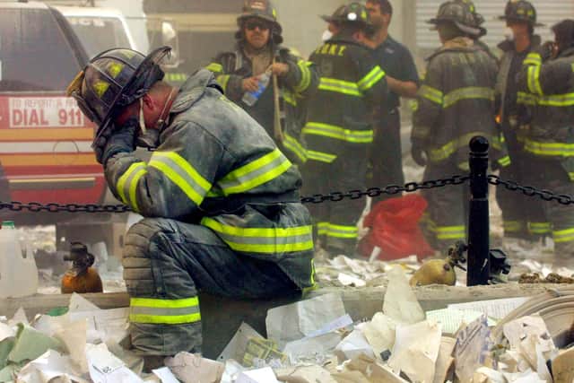 Firefighter Gerard McGibbon, of Engine 283 in Brownsville, Brooklyn, prays amid the ruins of the World Trade Center buildings (Picture: Mario Tama/Getty Images)