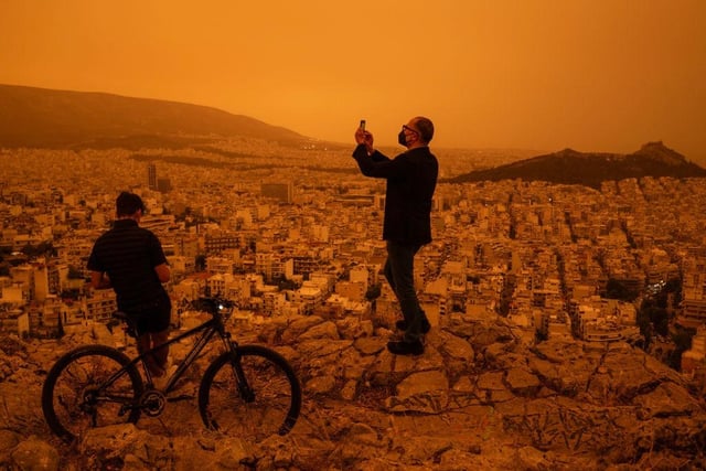 Residents turned out to snap pictures of the dust storm, which turned the city orange.