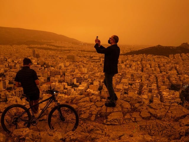 Residents turned out to snap pictures of the dust storm, which turned the city orange.