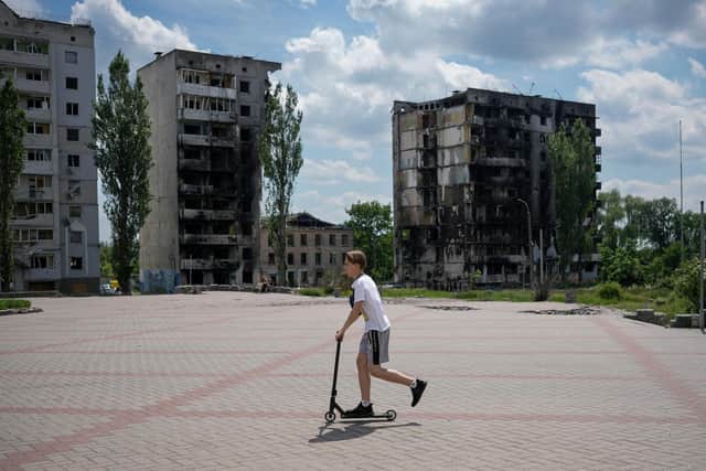 A boy scooters past bomb destroyed buildings that are waiting to be demolished in Borodianka, Ukraine. Picture: Christopher Furlong/Getty Images