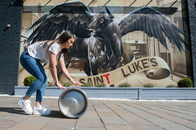 Jennifer Morrison, 30, General manage of St Luke's, Glasgow moves a keg of beer as the venue gears up for reopening.