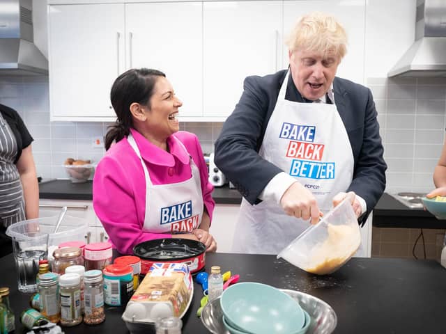 Home secretary Priti Patel looks on as Prime Minister Boris Johnson tries his hand at baking during a visit to the HideOut Youth Zone in Manchester. Picture: Stefan Rousseau-WPA Pool/Getty Images)