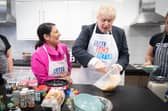 Home secretary Priti Patel looks on as Prime Minister Boris Johnson tries his hand at baking during a visit to the HideOut Youth Zone in Manchester. Picture: Stefan Rousseau-WPA Pool/Getty Images)