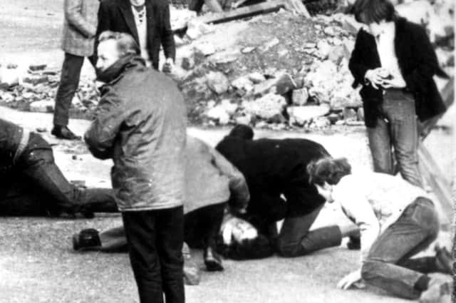 A man receives attention during the Bloody Sunday shootings in Londonderry, Northern Ireland, in 1972 (Picture: PA Wire)