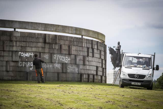 Workers clean graffiti that reads "Robert was a racist bring down the statue" at the Robert the Bruce rotunda in Bannockburn. PIC: Jane Barlow/PA Wire.