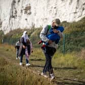A migrant family walks along the coast at Kingsdown Beach in Deal, England (Picture: Luke Dray/Getty Images)
