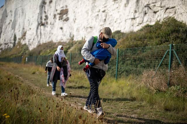 A migrant family walks along the coast at Kingsdown Beach in Deal, England (Picture: Luke Dray/Getty Images)