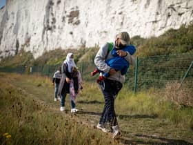 A migrant family walks along the coast at Kingsdown Beach in Deal, England (Picture: Luke Dray/Getty Images)