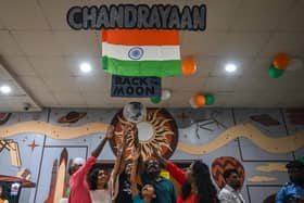 Visitors touch a picture of the moon at Nehru planetarium as they gather to witness the landing of the Indian Space Research Organisation's (ISRO) Chandrayaan-3 on the moon, in New Delhi . India is aiming to become the first nation to land a spacecraft on the Moon's south pole, days after a Russian probe crashed in the same region.