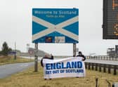 An official sign on the border welcomes people to Scotland, as an unofficial one strikes a rather different tone (Picture: Colin D Fisher/SWNS)