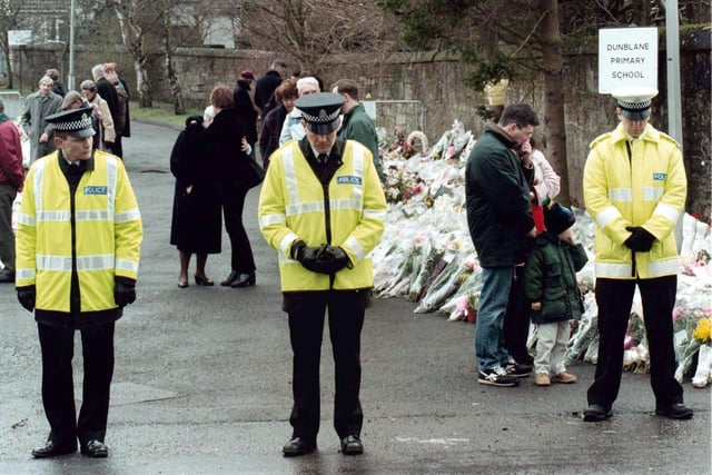 Three Dunblane policemen observing a one minutes silence outside the gates of Dunblane Primary School, where sixteen children and their teacher Gwen Mayor were tragically killed on March 13, 1996.