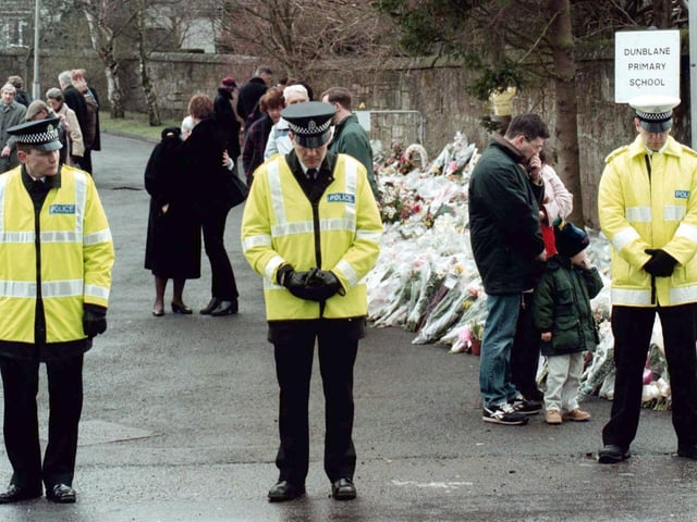 Three Dunblane policemen observing a one minutes silence outside the gates of Dunblane Primary School, where sixteen children and their teacher Gwen Mayor were tragically killed on March 13, 1996.