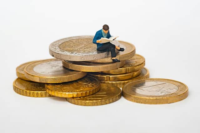 Man sat on a stack of coins