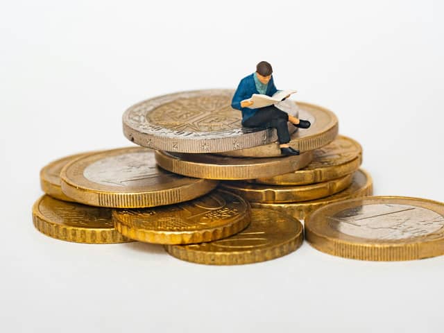 Man sat on a stack of coins