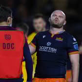 Dave Cherry grimaces as he receives treatment on his injured arm during Edinburgh's URC match against Ulster.  (Photo by Craig Williamson / SNS Group)
