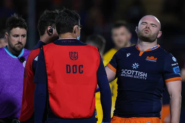 Dave Cherry grimaces as he receives treatment on his injured arm during Edinburgh's URC match against Ulster. (Photo by Craig Williamson / SNS Group)