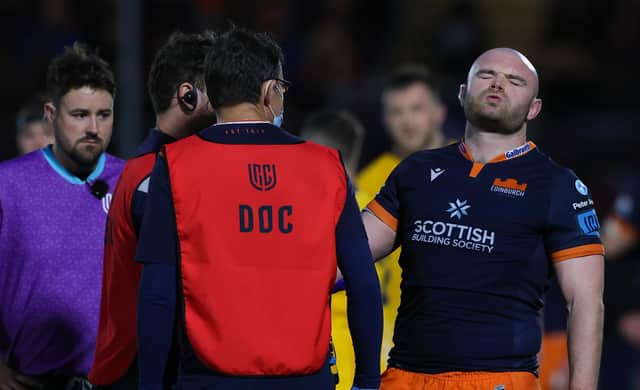 Dave Cherry grimaces as he receives treatment on his injured arm during Edinburgh's URC match against Ulster. (Photo by Craig Williamson / SNS Group)