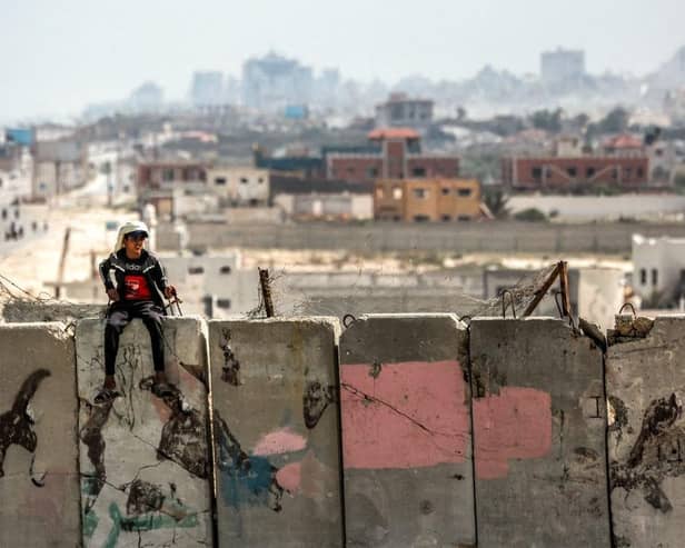 A boy sits atop a concrete barrier in al-Zahra in the central Gaza Strip. Picture: AFP via Getty Images