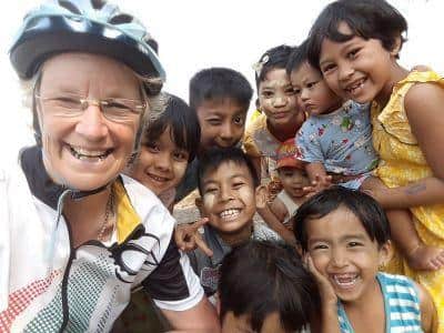 Muriel Thomson with a group of kids at a village school she visited on a cycle down India.