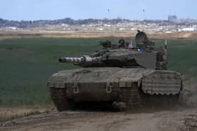 An Israeli Defense Forces tank drives away from the Gaza Strip, as seen from southern Israel. Picture: AP Photo/Tsafrir Abayov