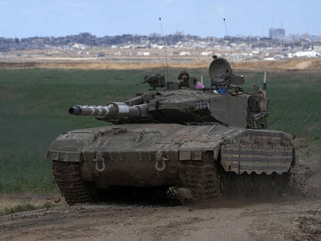 An Israeli Defense Forces tank drives away from the Gaza Strip, as seen from southern Israel. Picture: AP Photo/Tsafrir Abayov